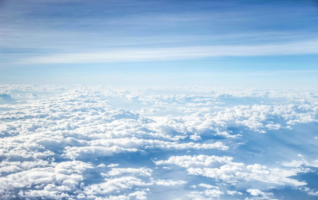 Scenic aerial view of fluffy clouds and serene blue sky, offering a tranquil and dreamy atmosphere.